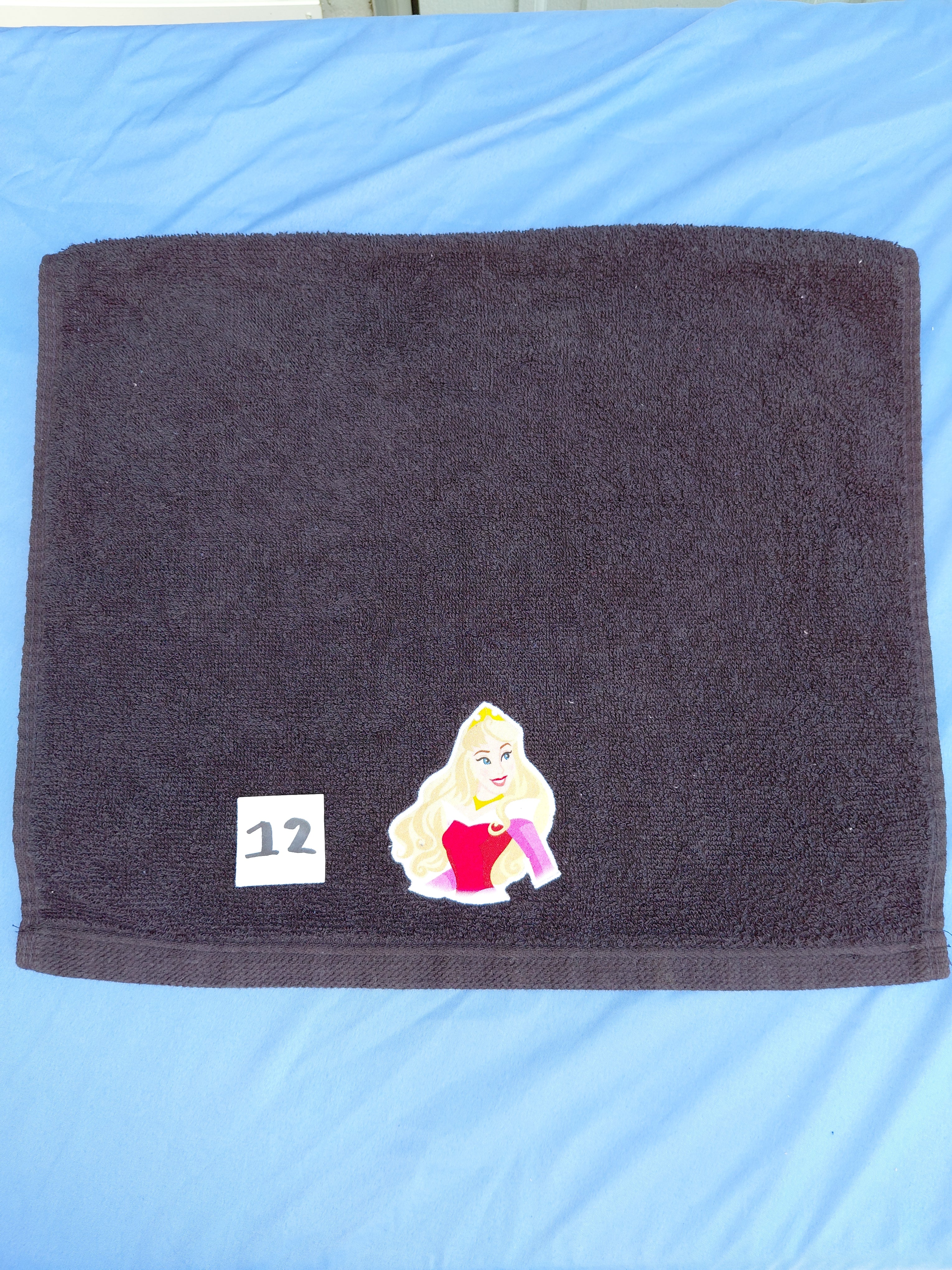 Black embellished hand towel with princess design, reinforced hem