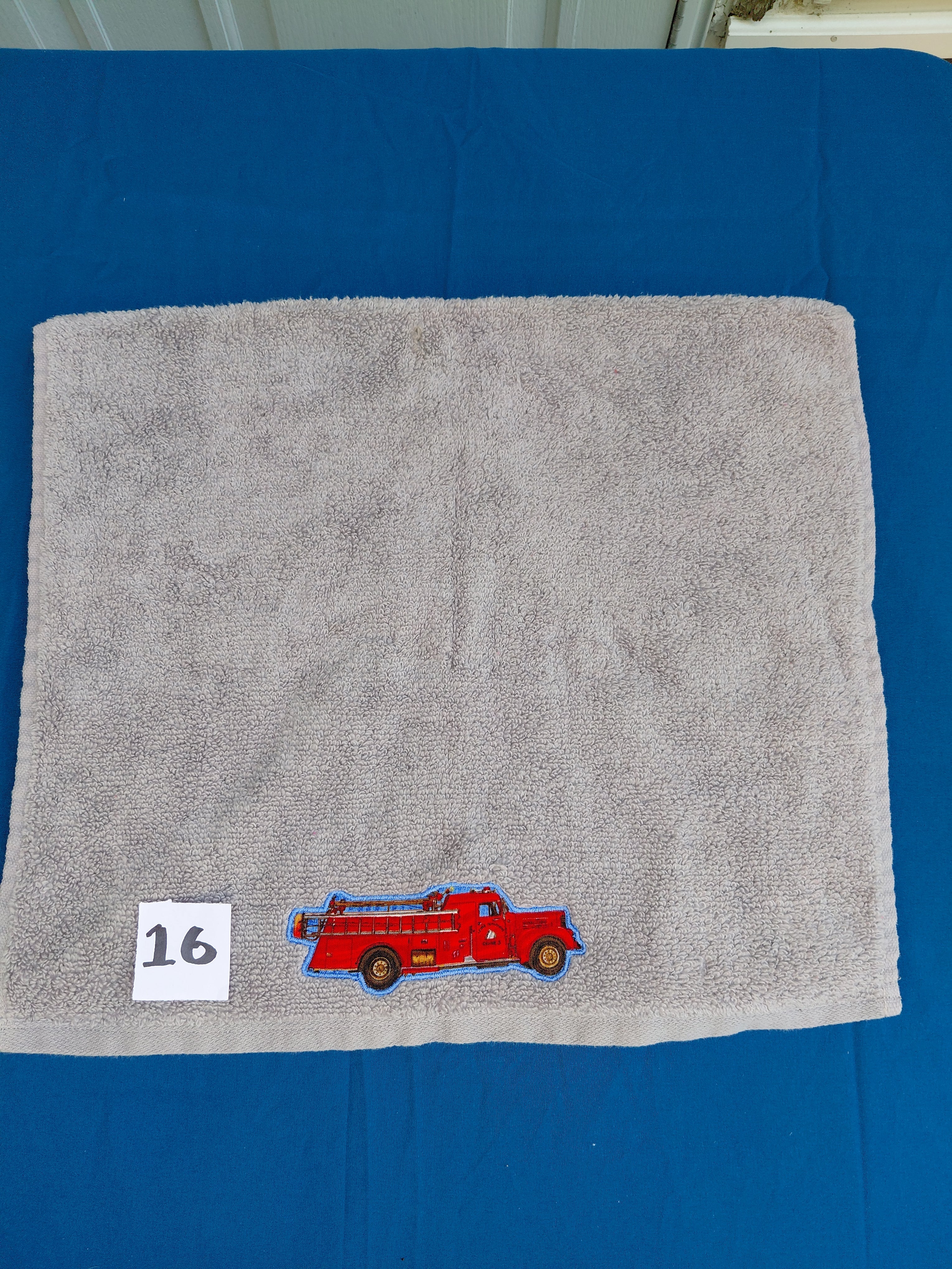 Stormy sky gray embellished hand towel with fire engine, reinforced hem