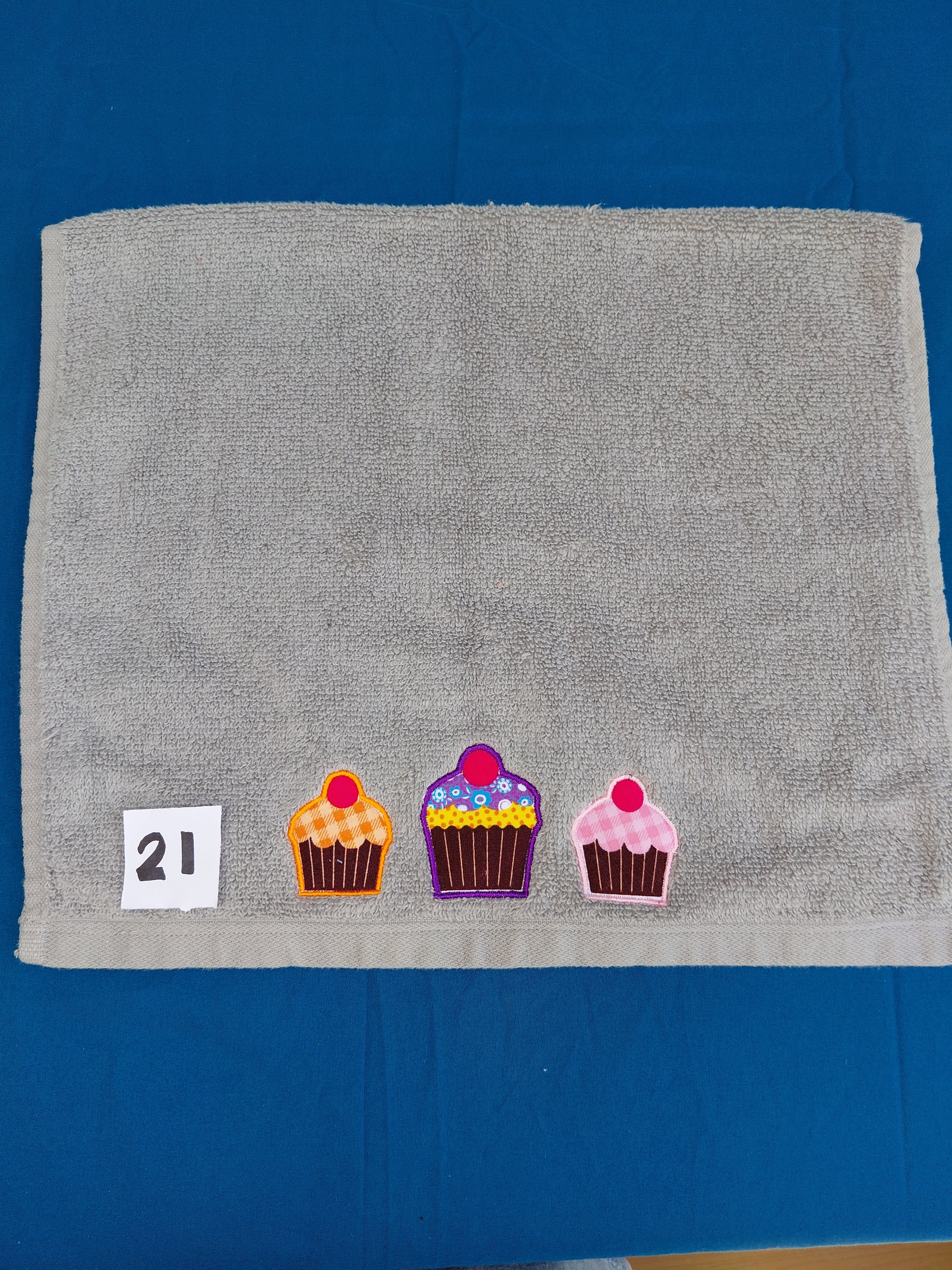 Stormy gray embellished hand towel with three cupcakes, reinforced hem

