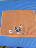 Burnt orange embellished hand towel with rooster and three eggs, reinforced hem