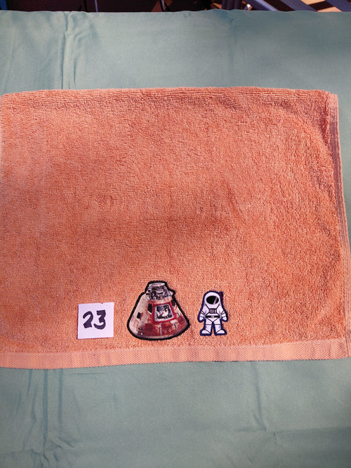Burnt orange embellished hand towel with astronaut and space capsule, reinforced hem