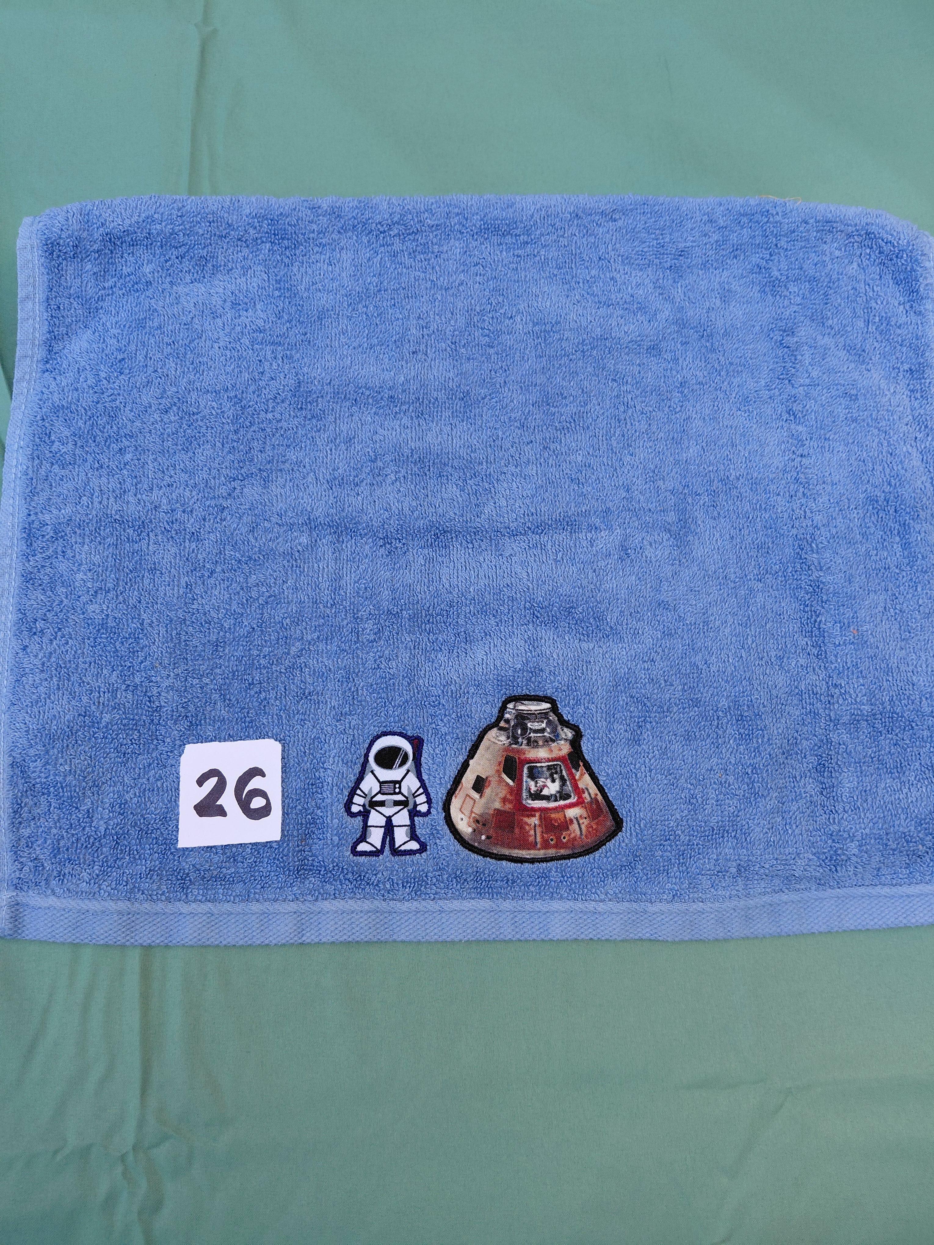 Sky blue embellished hand towel with astronaut and space capsule, reinforced hem