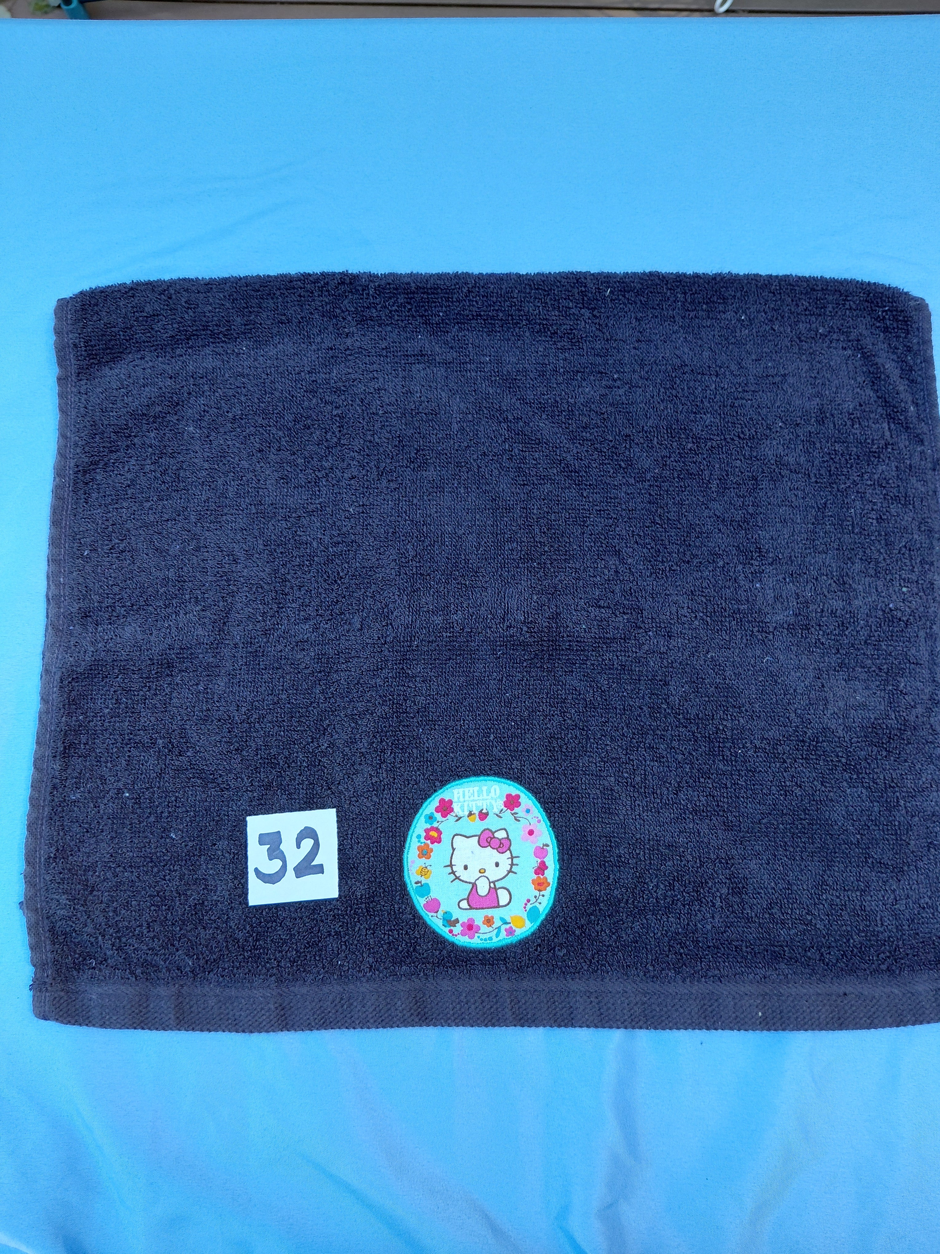 Black handcrafted embellished hand towel with kitty appliqué, reinforced hem
