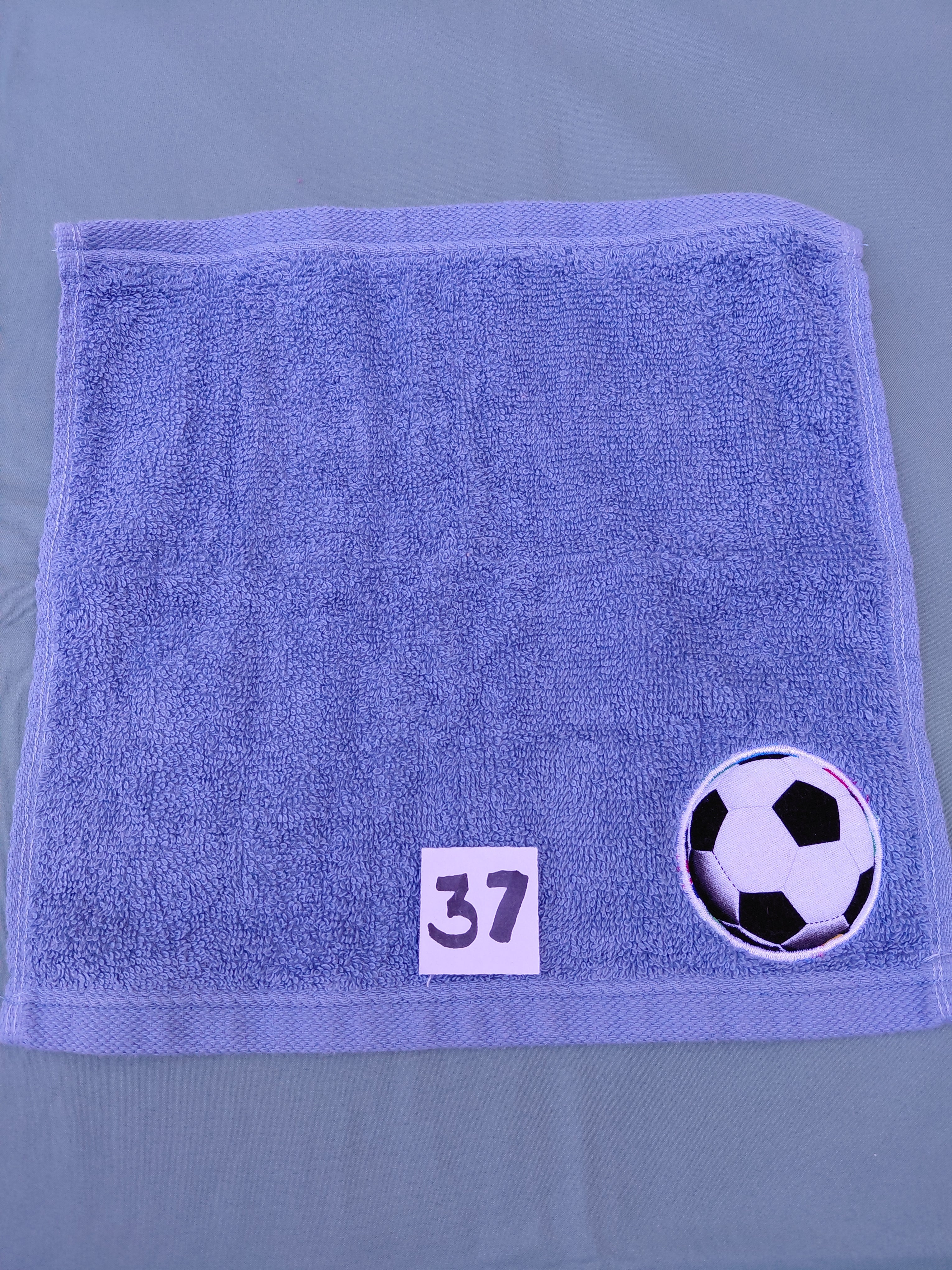 Sky blue handcrafted embellished washcloth with soccer ball appliqué, reinforced hem