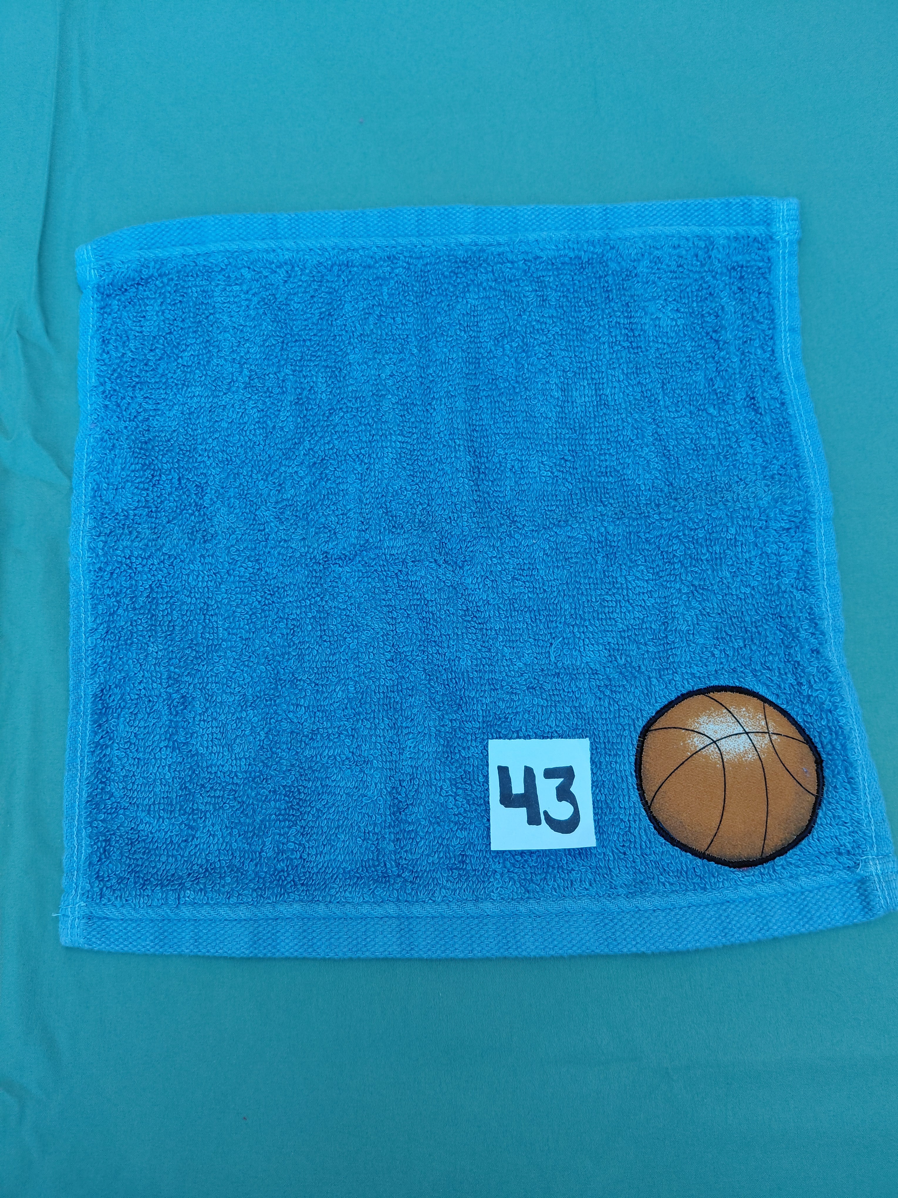 Sky blue handcrafted embellished washcloth with basketball appliqué, reinforced hem
