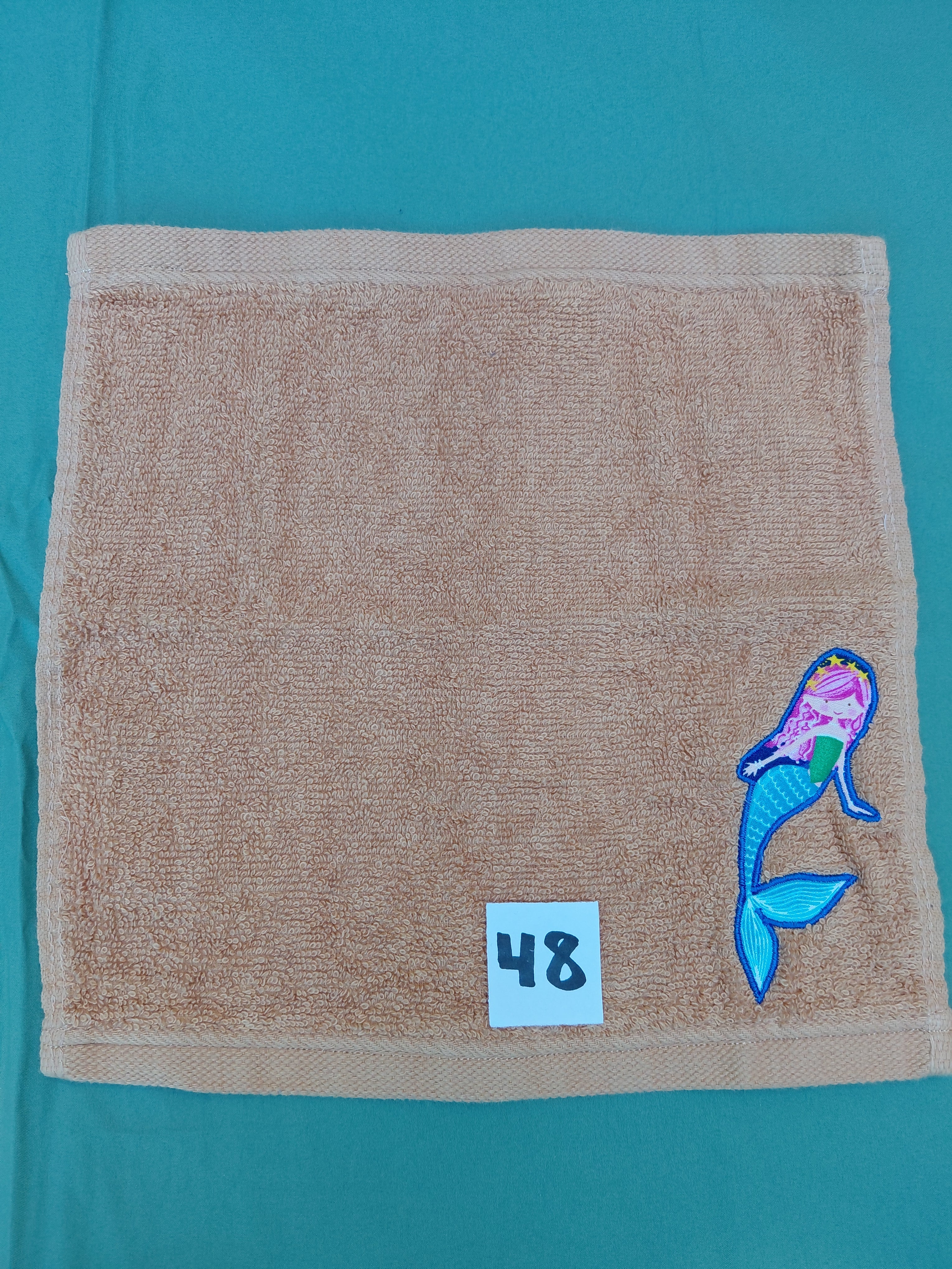 Burnt orange handcrafted embellished washcloth with mermaid appliqué, reinforced hem