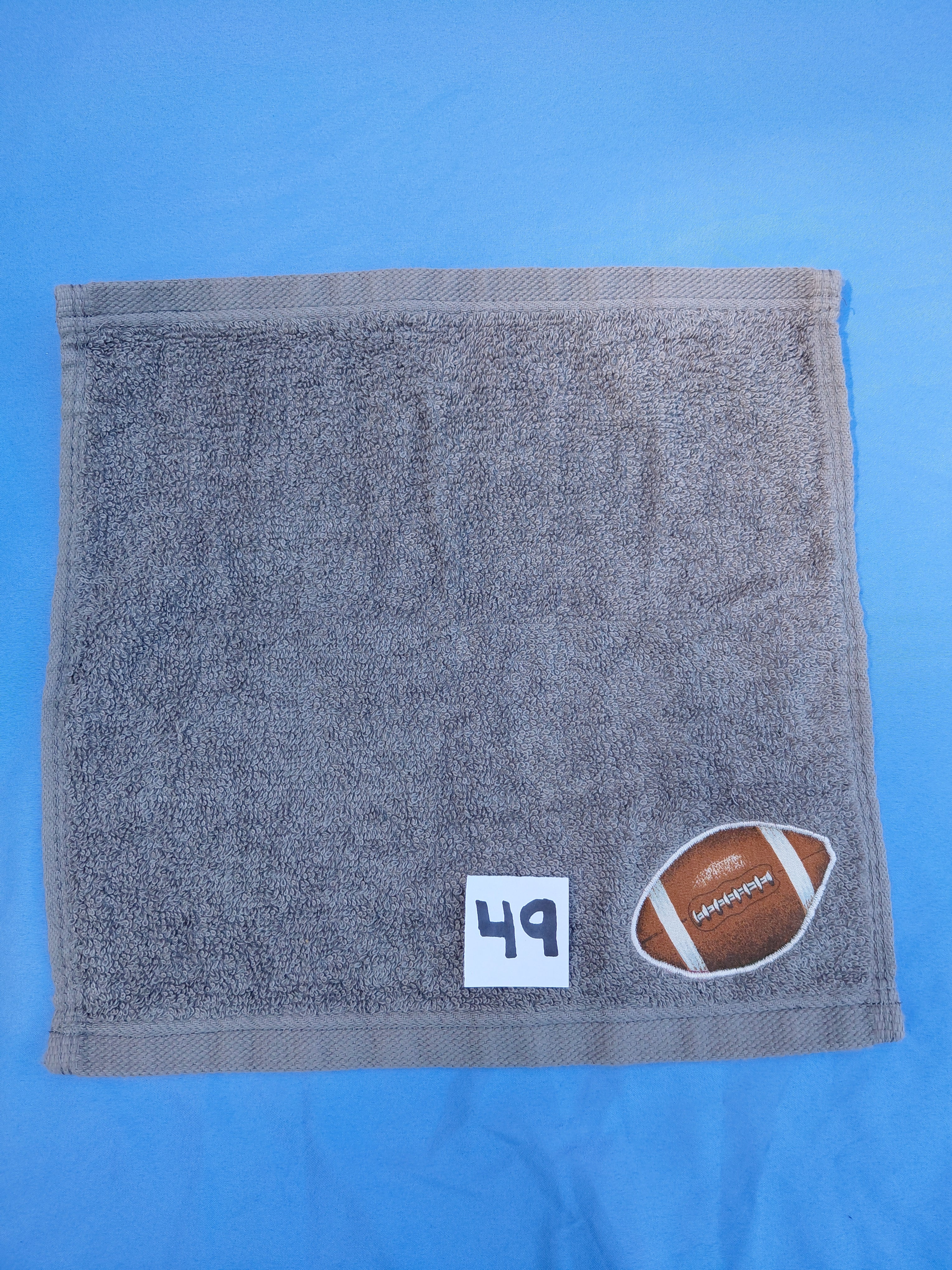 Stormy sky gray handcrafted embellished washcloth with football appliqué, reinforced hem