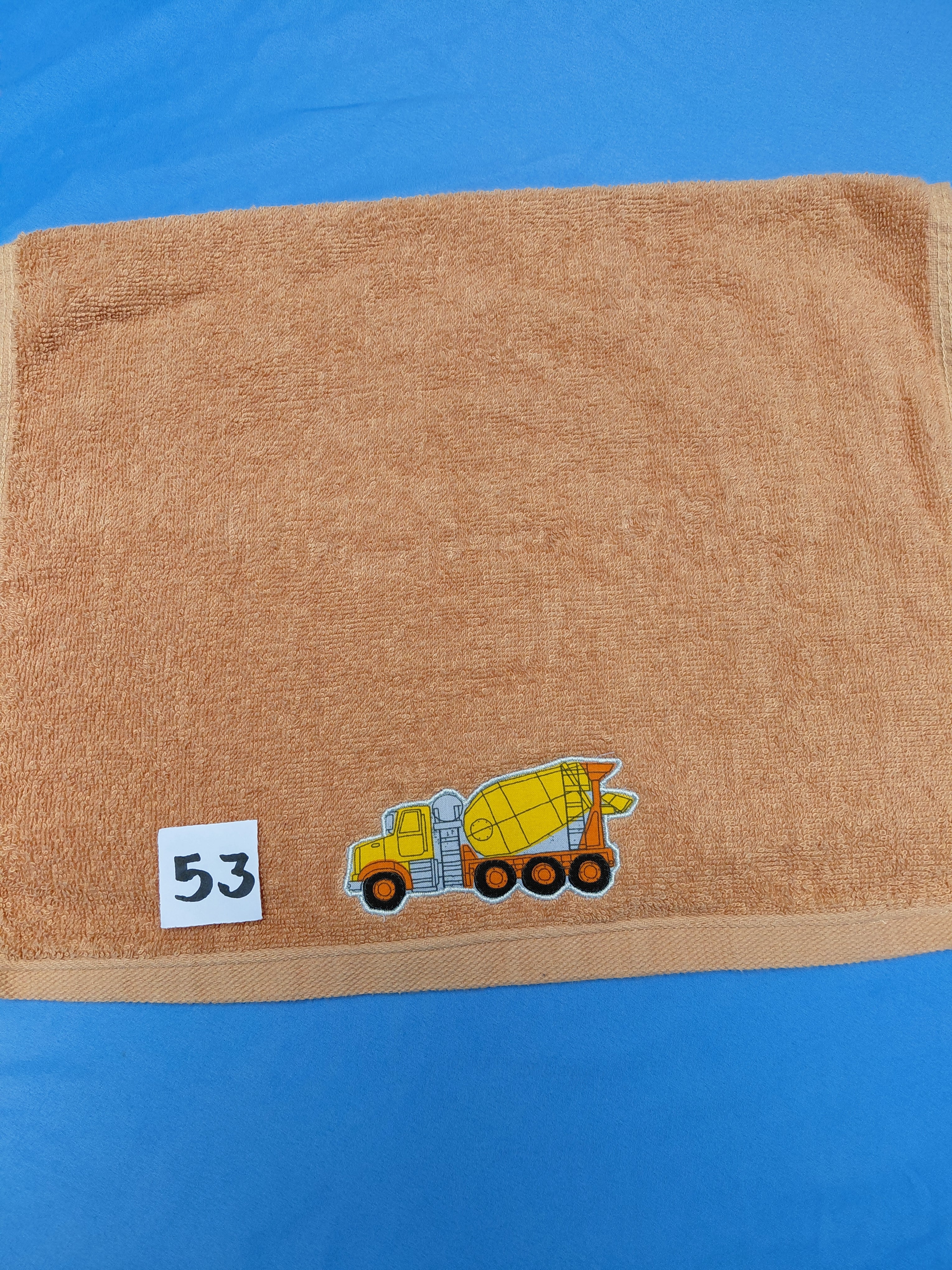 Burnt orange handcrafted embellished hand towel with cement mixer appliqué, reinforced hem