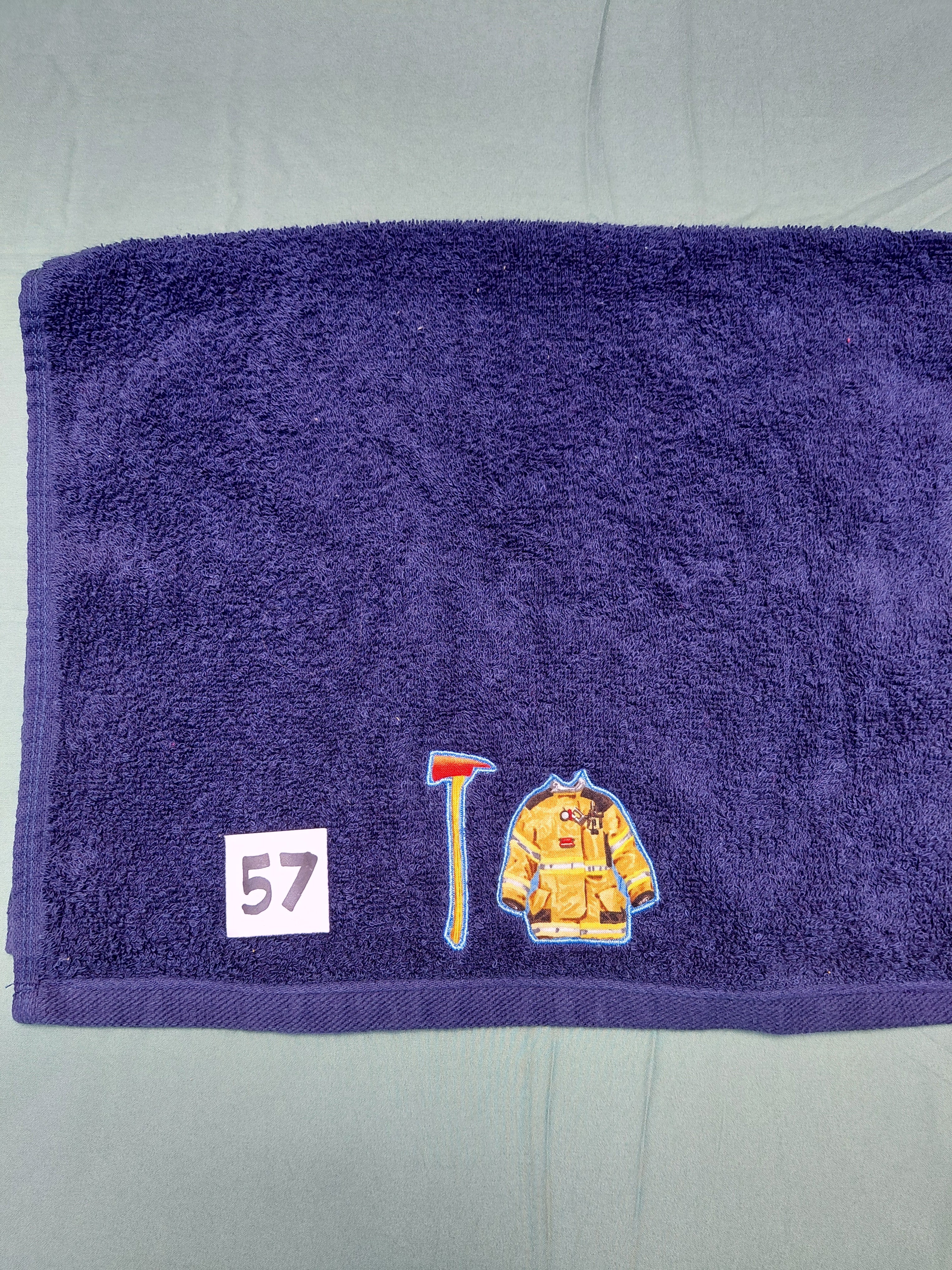 Dark blue handcrafted embellished hand towel with firefighter appliqué, reinforced hem