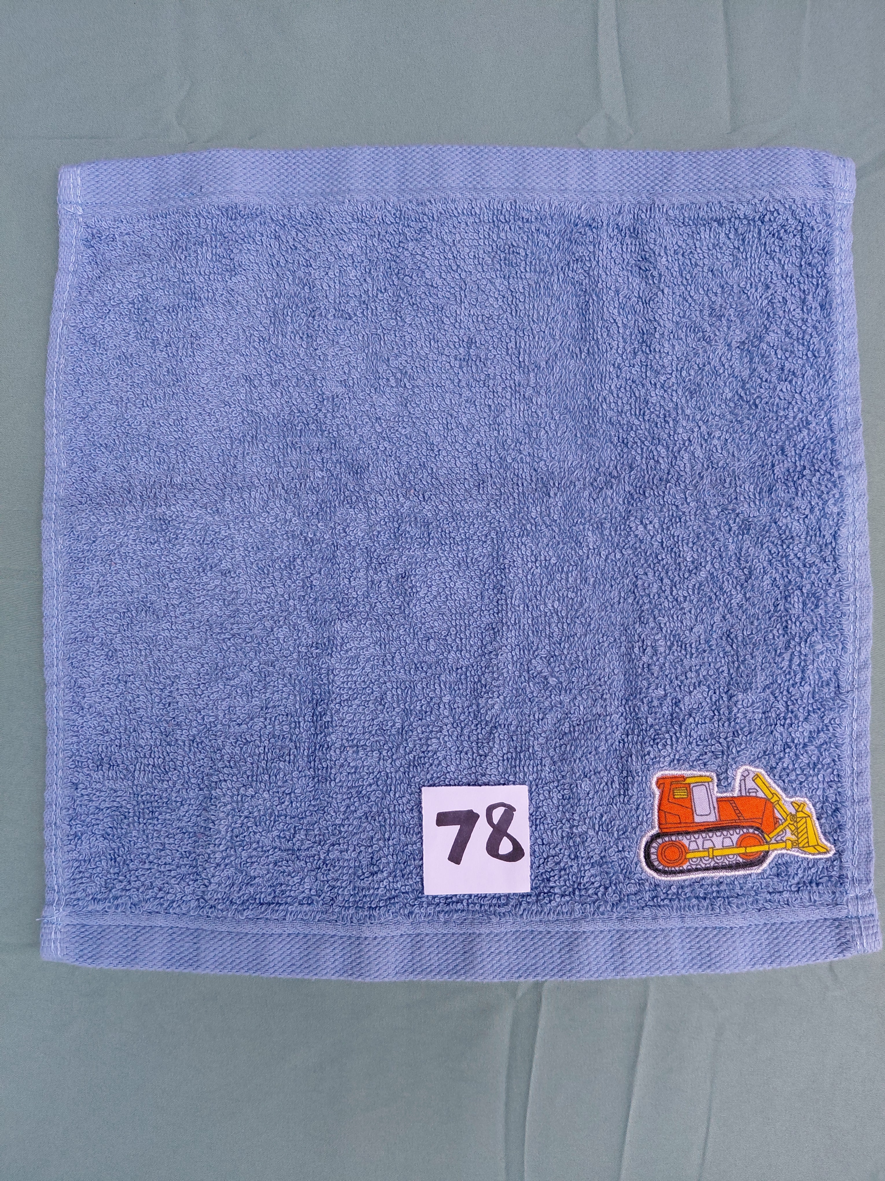 Sky blue handcrafted embellished washcloth with bulldozer appliqué, reinforced hem