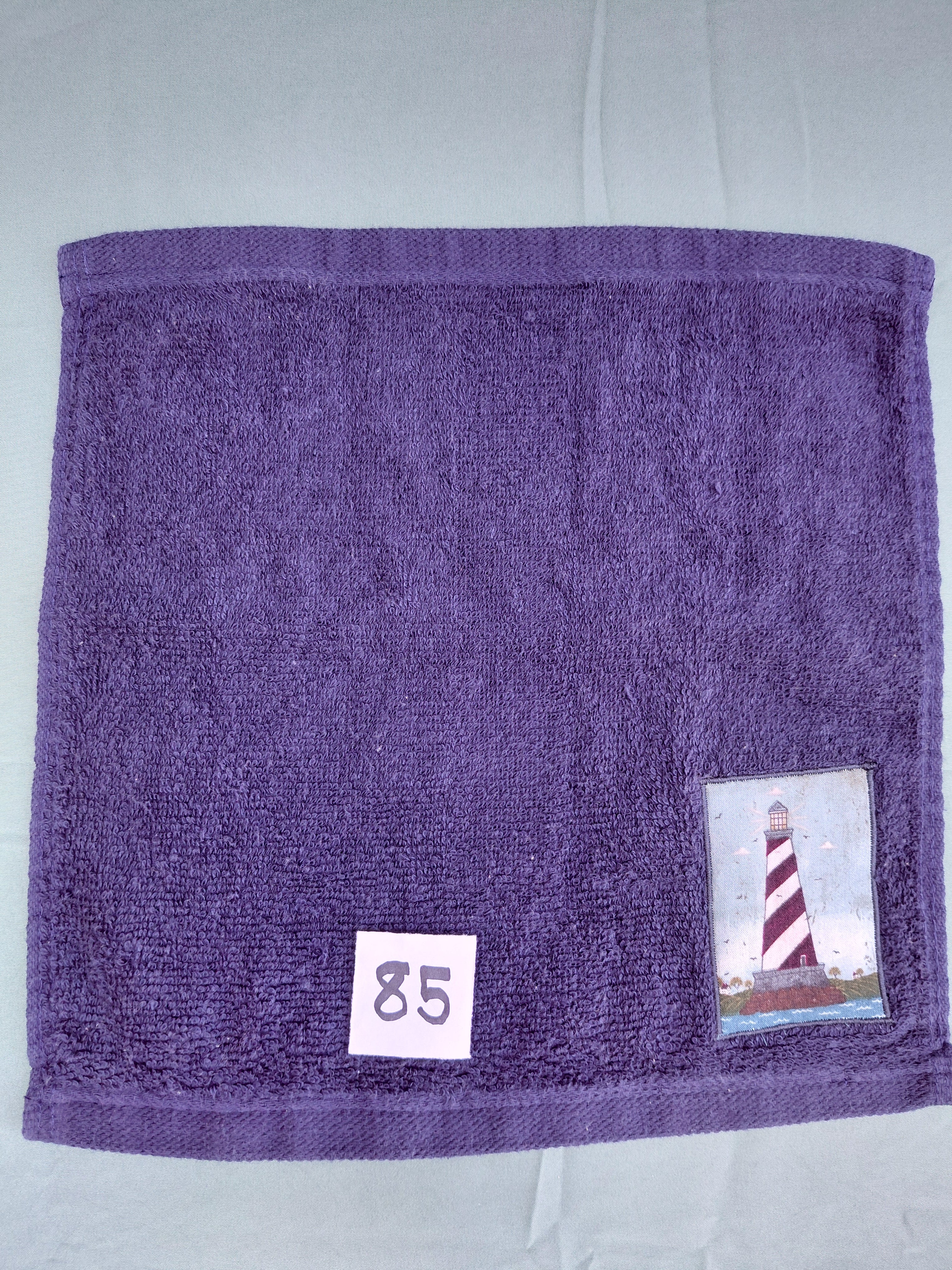 Dark blue handcrafted embellished washcloth with lighthouse appliqué, reinforced hem