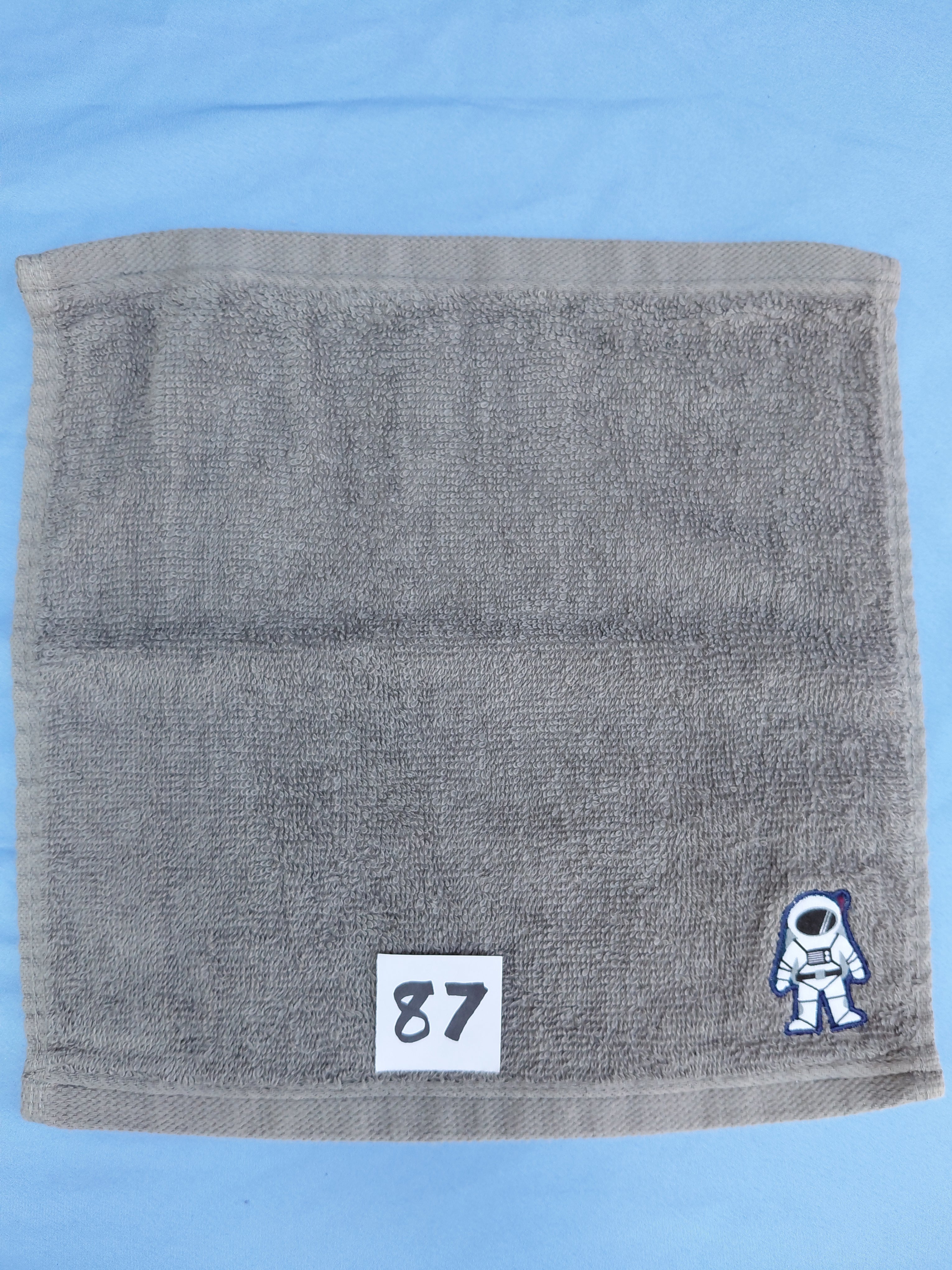 Stormy sky gray handcrafted embellished washcloth with astronaut appliqué, reinforced hem