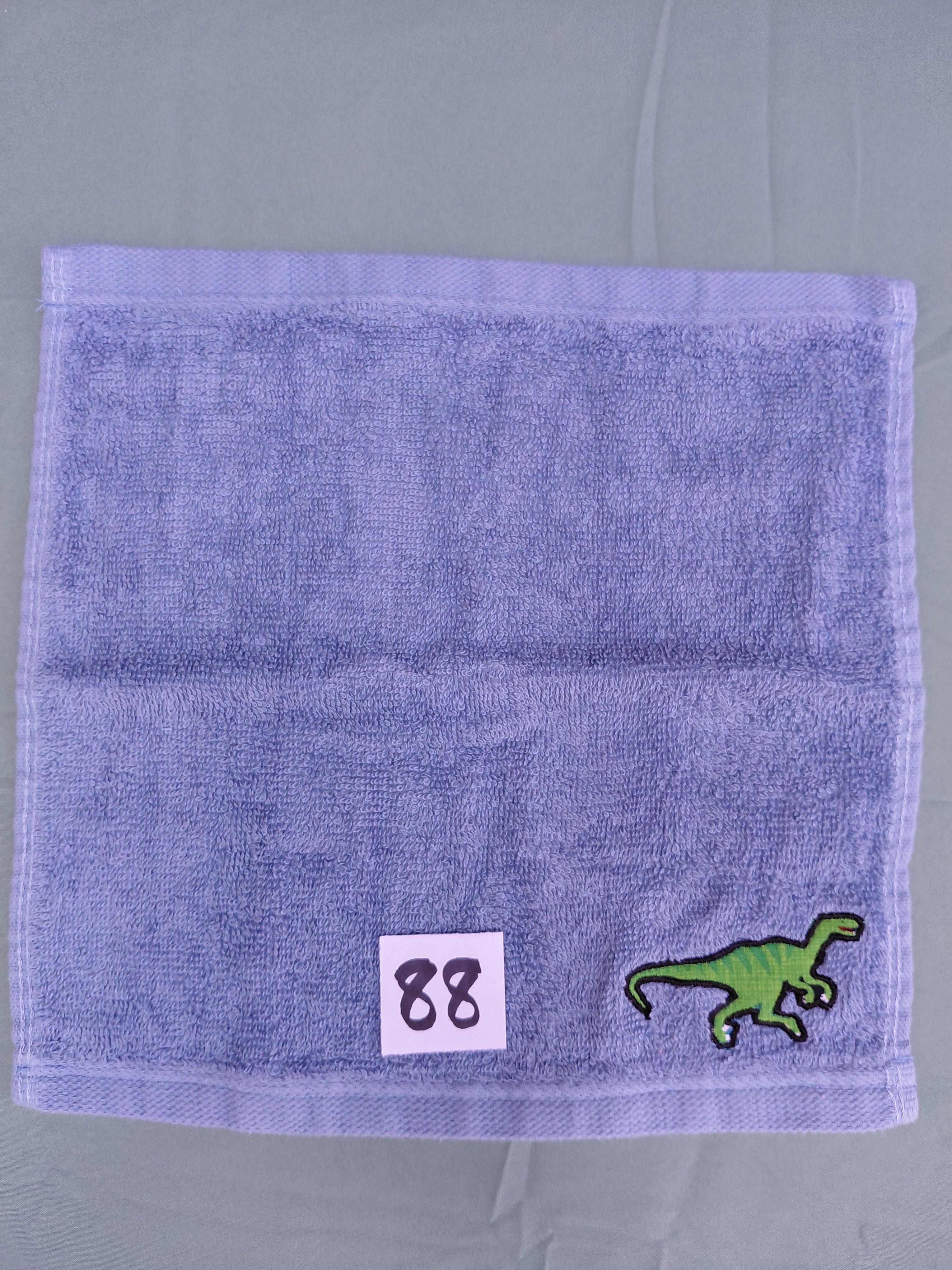 Sky blue handcrafted embellished washcloth with dinosaur appliqué, reinforced hem