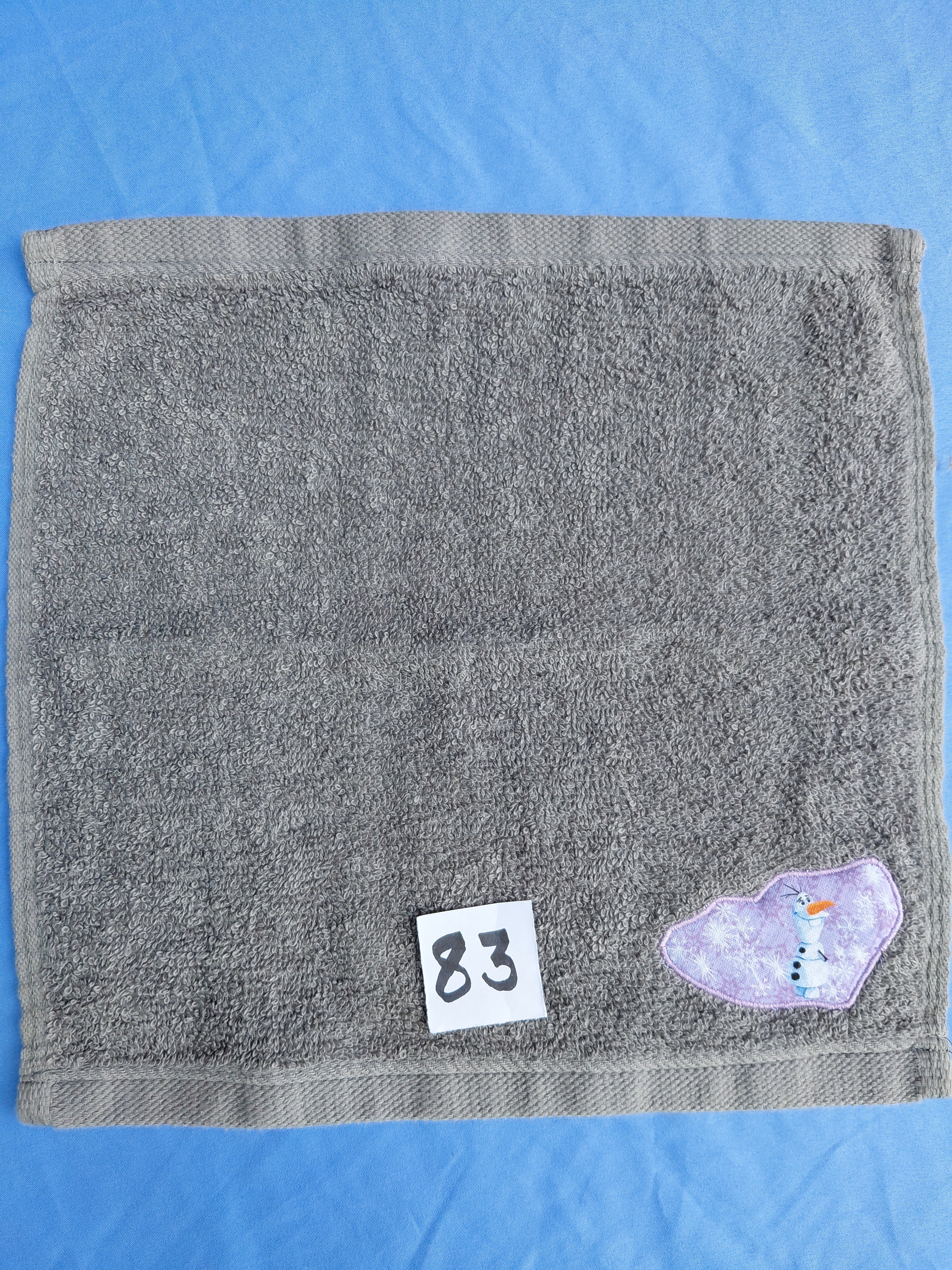 Stormy sky gray handcrafted embellished washcloth with snowman appliqué, reinforced hem